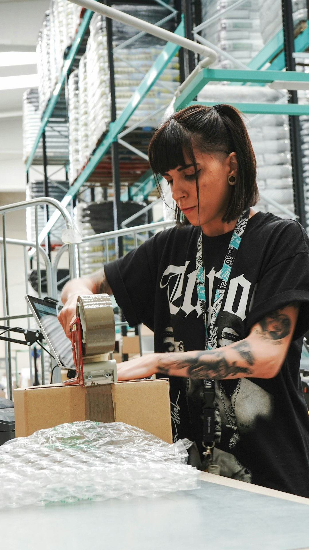 Worker sealing and checking product packaging in a warehouse